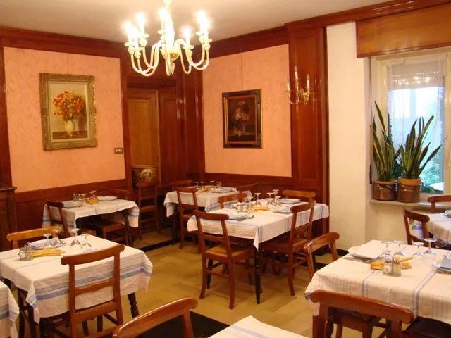 La sala con lampadari, boiserie in legno e tovaglie a righe
